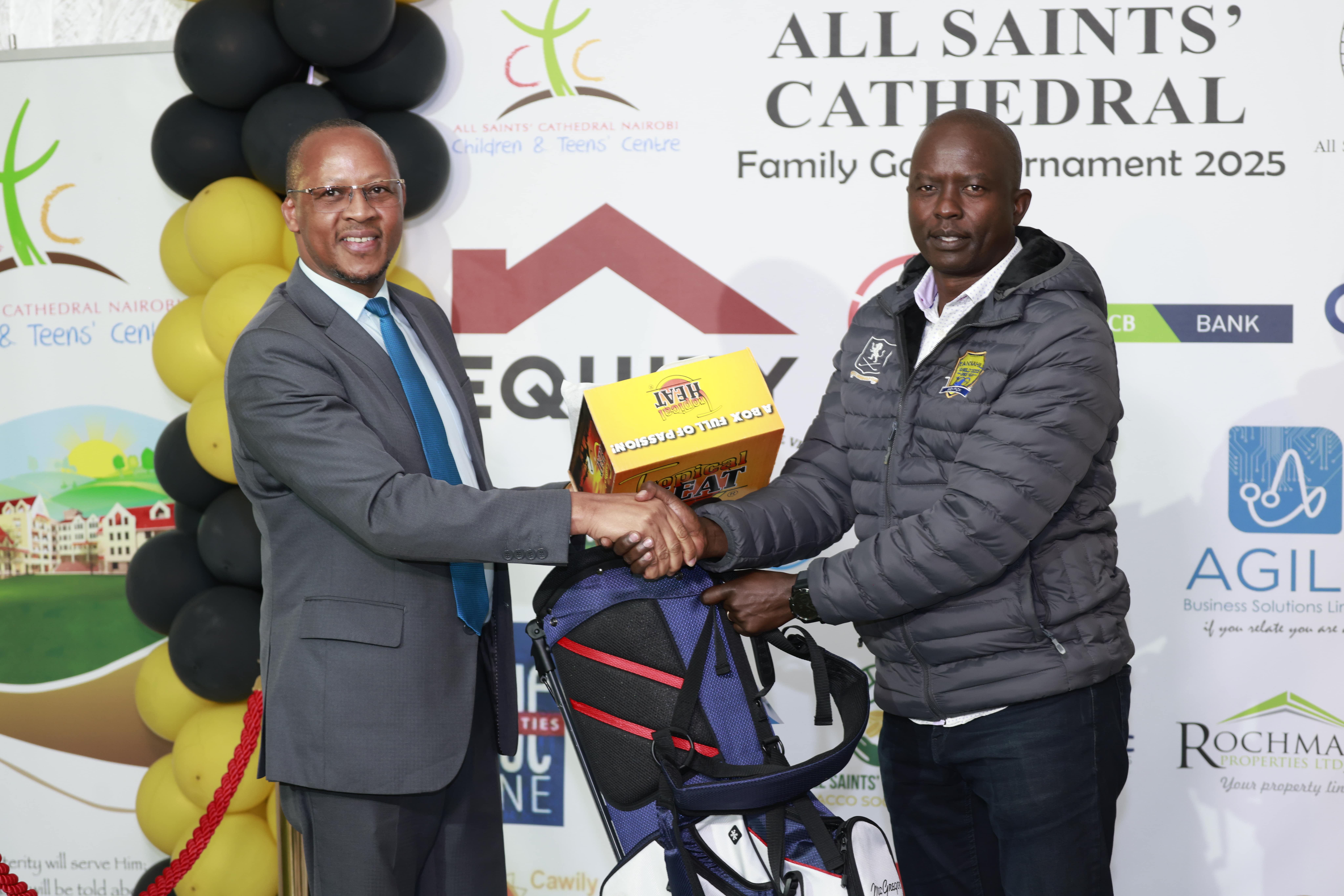 Man in a suit presenting a prize and golf bag to another man